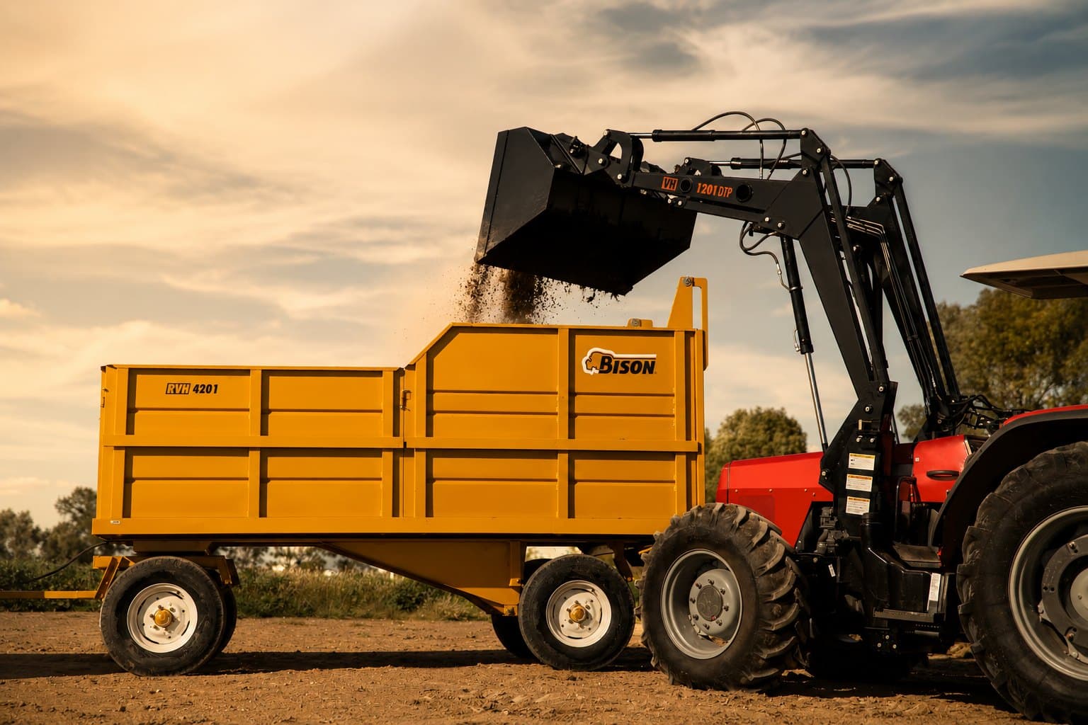 Cargadora frontal BISON VH-1201 DTP cargando un remolque RVH en campo